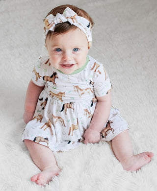 Baby girl wearing headband bow and bamboo bodysuit dress for babies and toddlers in Perfect Ponies print