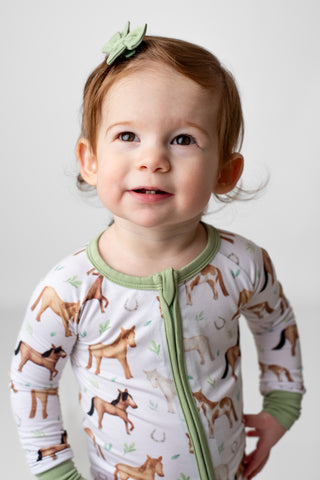 Baby girl wearing bamboo pajamas for toddlers and kids in Perfect Ponies print