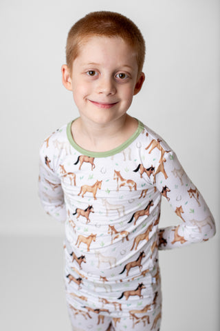 Boy wearing bamboo pajamas for toddlers and kids in Perfect Ponies print