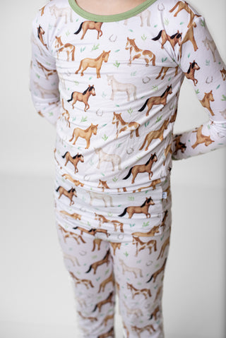 Boy wearing bamboo pajamas for toddlers and kids in Perfect Ponies print
