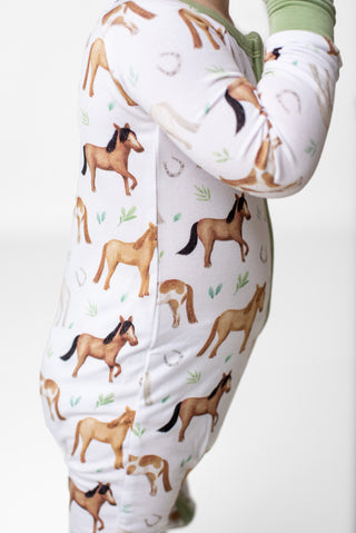 Boy wearing bamboo zipper pajamas for toddlers and kids in Perfect Ponies print