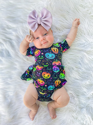 Girl wearing bamboo bodysuit dress for babies and toddlers in Halloween Pumpkins print