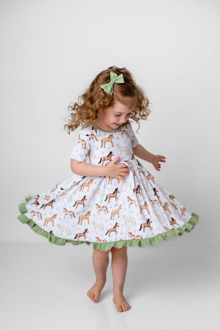 Girl wearing bamboo dress for toddlers and kids in Perfect Ponies print