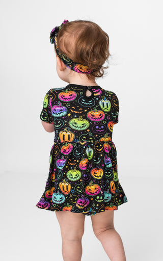 Girl wearing bamboo bodysuit dress for babies, toddlers, and kids in Halloween Pumpkins print