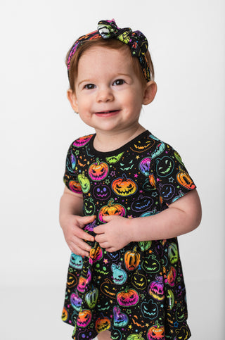 Girl wearing bamboo bodysuit dress for babies, toddlers, and kids in Halloween Pumpkins print