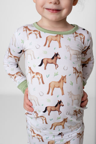 Girl wearing bamboo pajamas for toddlers and kids in Perfect Ponies print