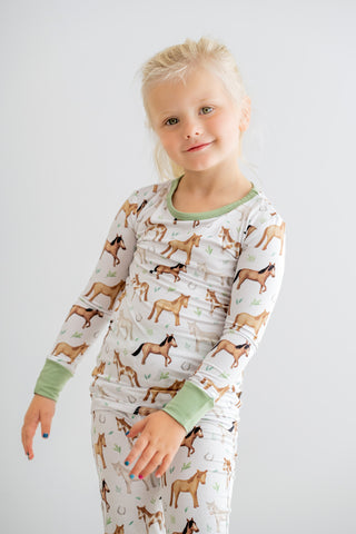 Girl wearing bamboo pajamas for toddlers and kids in Perfect Ponies print