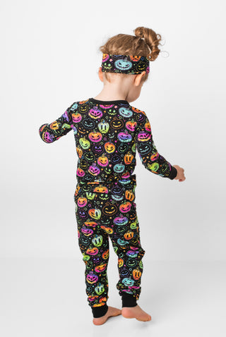 Girl wearing bamboo pajamas for toddlers and kids in Halloween Pumpkins print