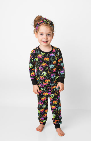 Girl wearing bamboo pajamas for toddlers and kids in Halloween Pumpkins print