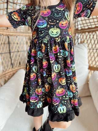 Girl wearing bamboo ruffle dress for toddlers and kids in Halloween Pumpkins print