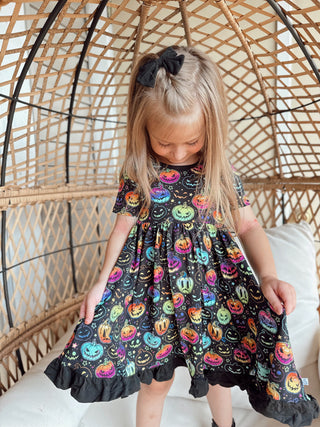 Girl wearing bamboo ruffle dress for toddlers and kids in Halloween Pumpkins print