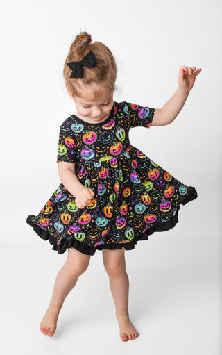 Girl twirling in bamboo ruffle dress for toddlers and kids in Halloween Pumpkins print