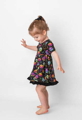 Girl twirling in bamboo ruffle dress for toddlers and kids in Halloween Pumpkins print